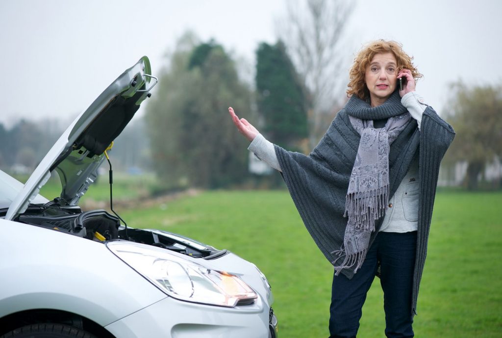 stranded stressed out woman roadside with broken down car